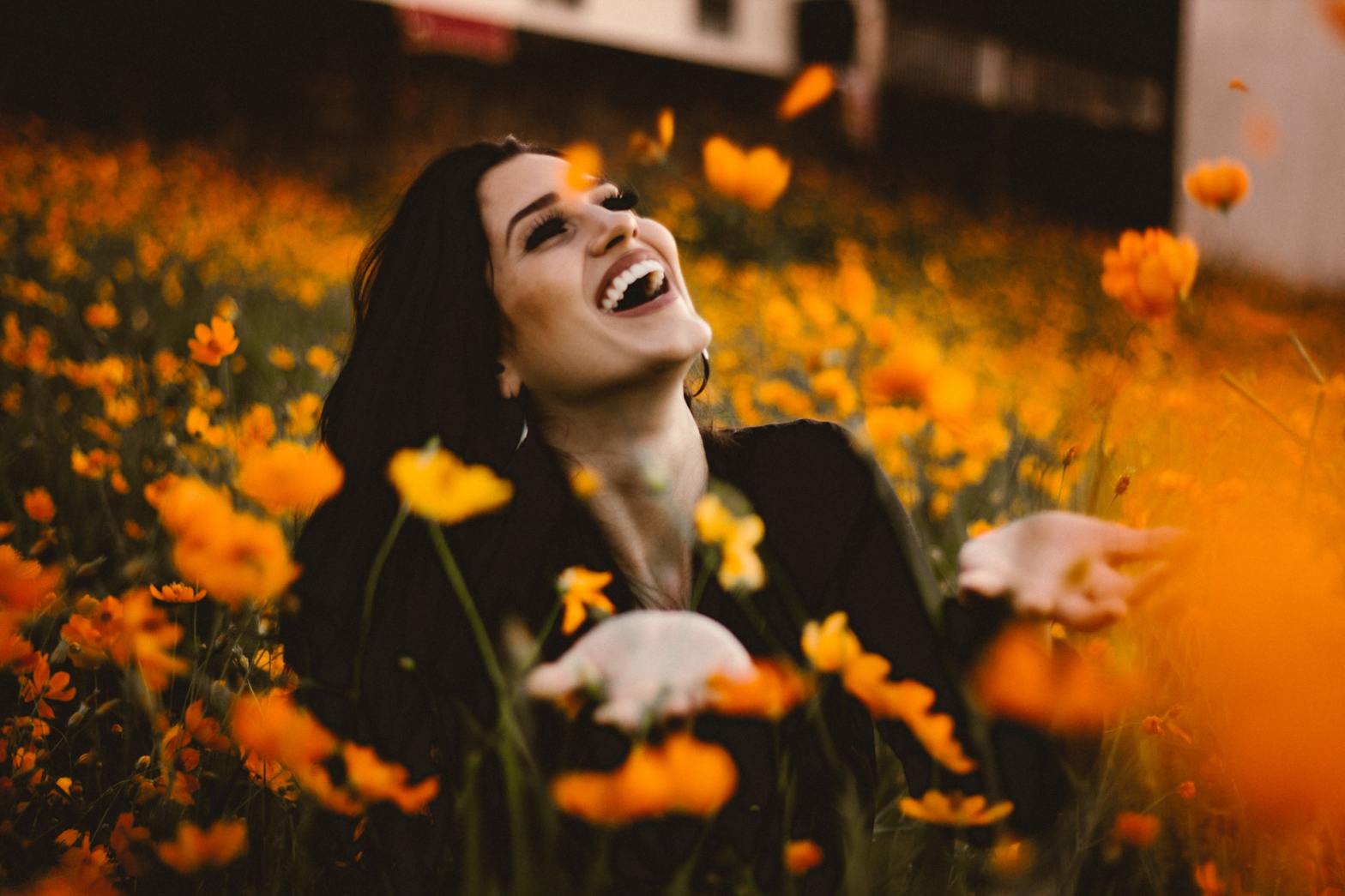 A smiling woman in the middle of a flower field