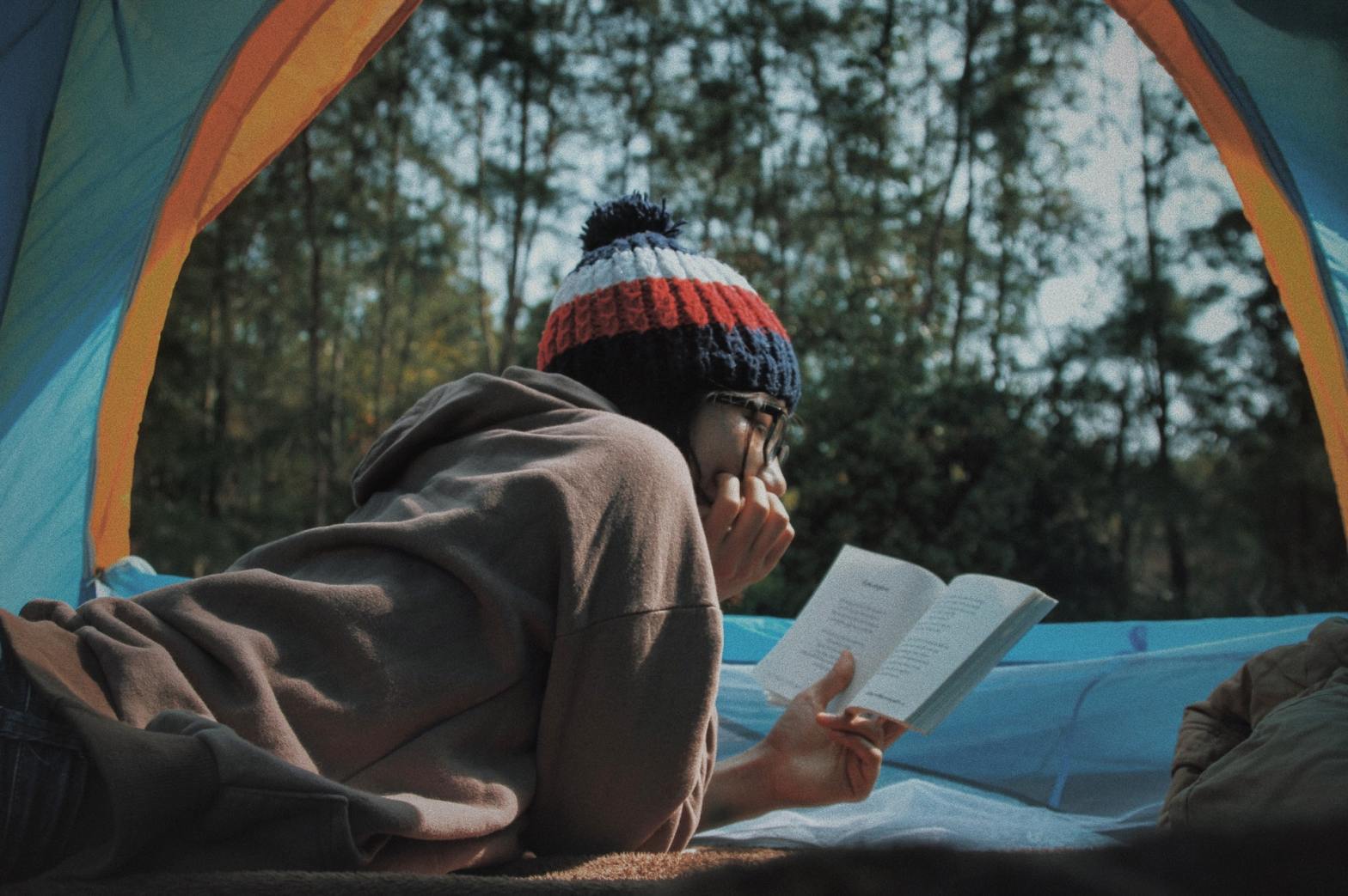 Girl reading a book in a tent