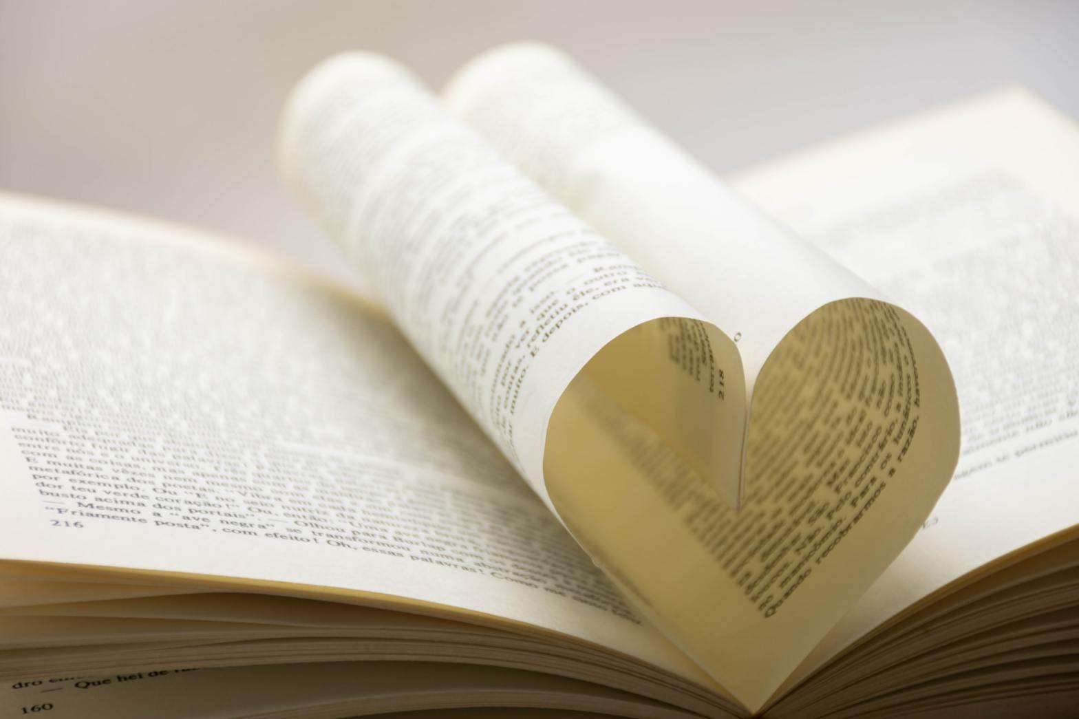 An open book with pages shaped into a heart