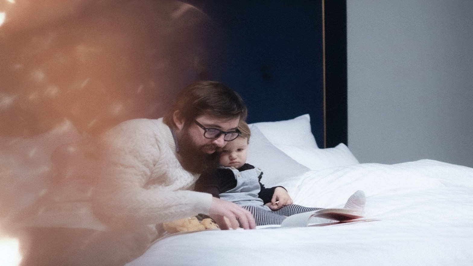 Father and son reading a book in bed