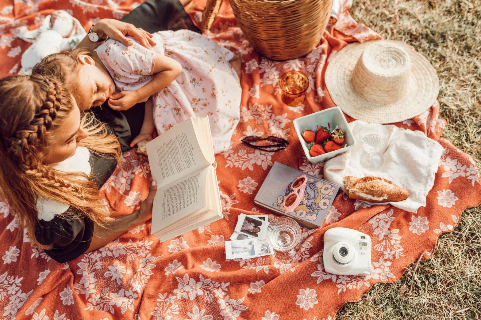 Mother and daughter on a picnic reading a book