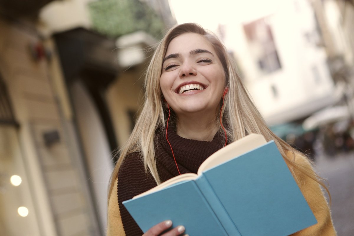 woman smiling while holding book why poetry elicits strong emotions